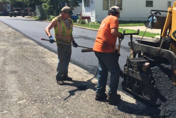 two workers work on road